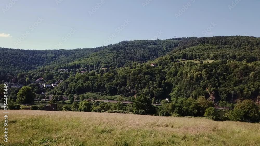 Slowly ascending over grass field with mountain in background, Heidelberg Germany. Slowly ascending over grass field with mountain in background, Heidelberg Germany.