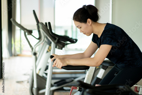 Asian woman make a muscles stretching before exercise. Sport woman practice a body exercise and body weight exercise in an indoor gym. Wellness and wellbeing concept.