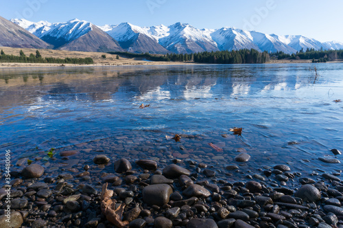 Winter mountain landscape with icy lake and snow-capped mountains