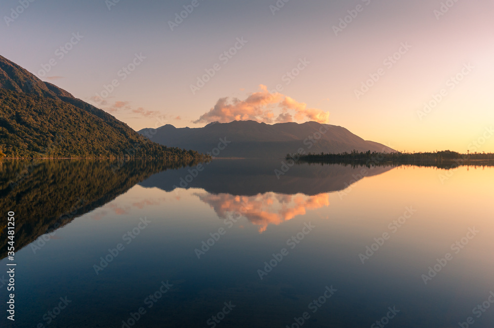 Lake landscape with mountain hills and reflection in still water