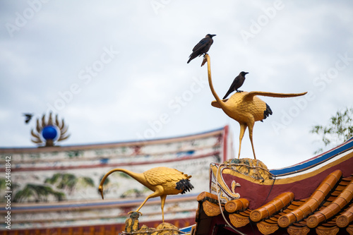 Real bird on top of Chinese Temple roof