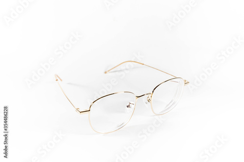 Gold frame spectacles glasses in a white isolated background