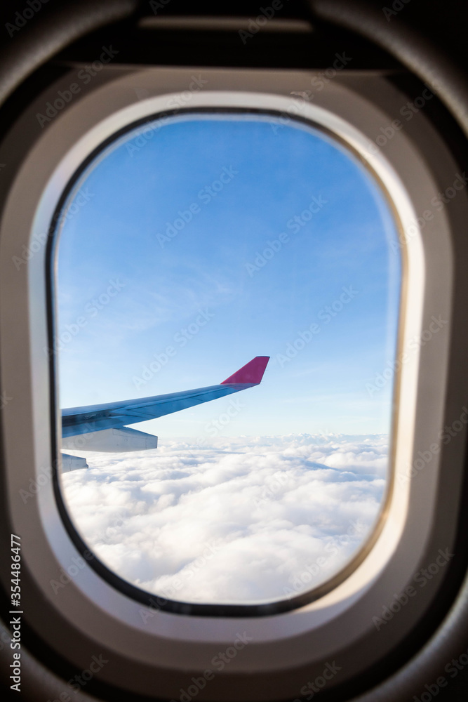 Plane wing view from inside plane in midair with blue sky cloud background Plane wing view from inside plane in midair with blue sky cloud background