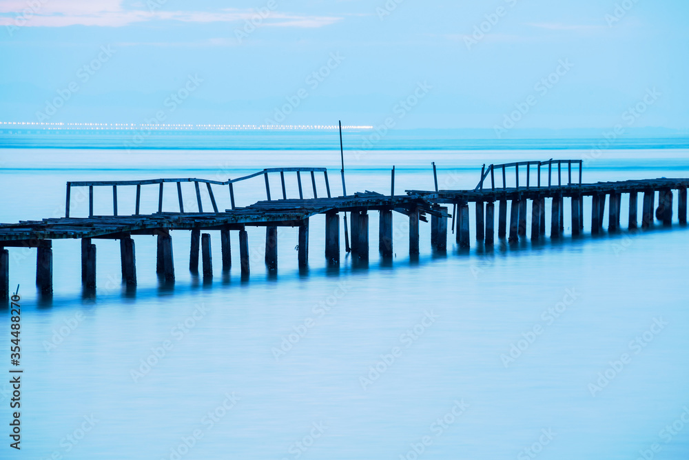 Long exposure view of wooden bridge in blue background