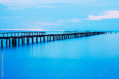 Long exposure view of wooden bridge in blue background © keongdagreat