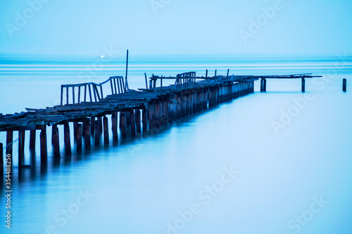 Long exposure view of wooden bridge in blue background