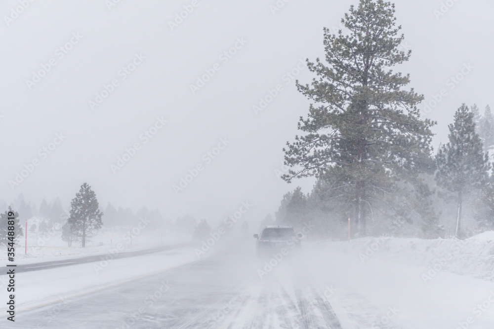 Obraz premium Travel on a snowy mountain road snowstorm
