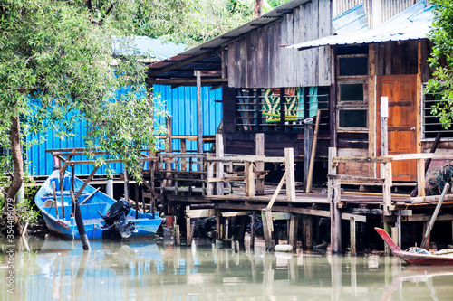 Wooden house by the river side view indicating poverty photo