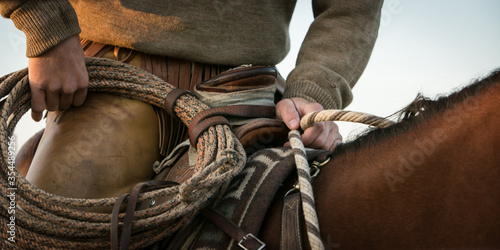 Western cowboy on horseback preparing to round up cattle
