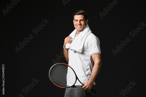 Sporty male tennis player on dark background © Pixel-Shot