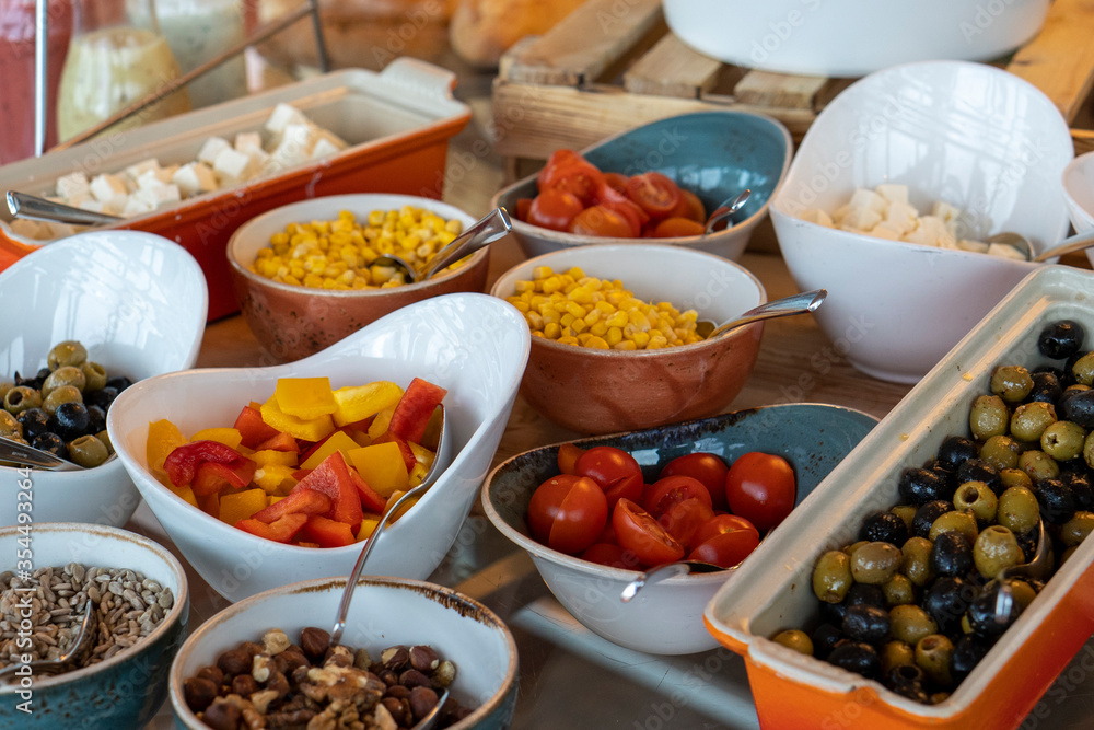Different salads, tomatoes, corn, olives and cheese
