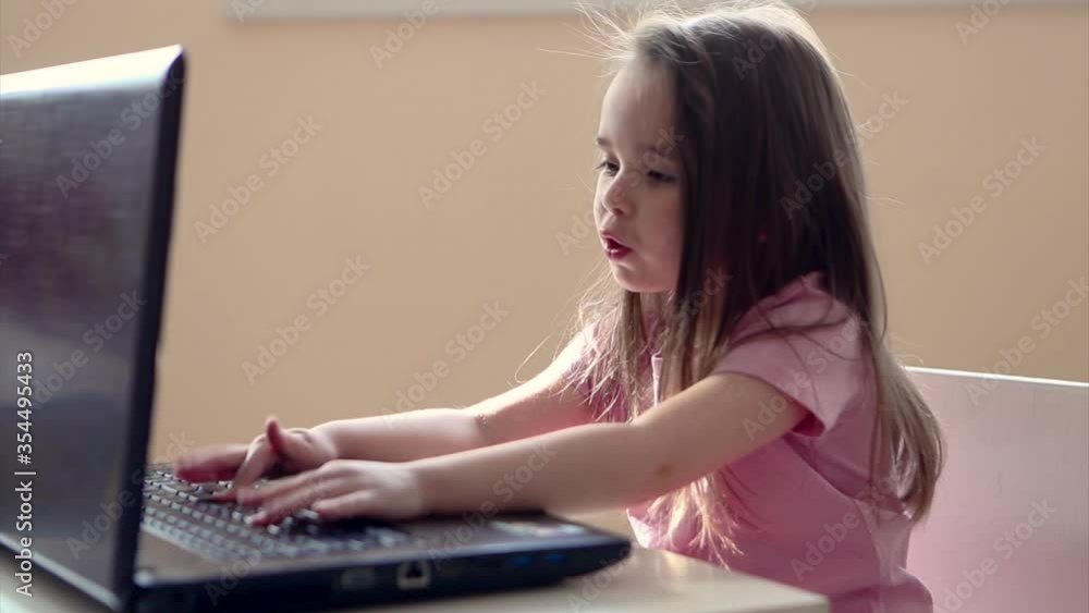 small child plays on computer. The child Prodigy learns the techniques of business Planning, home work, quarantine, self-isolation, protection from coronavirus, virus, home education, distance work. small child plays on computer. The child Prodigy learns the techniques of business Planning, home work, quarantine, self-isolation, protection from coronavirus, virus, home education, distance work.
