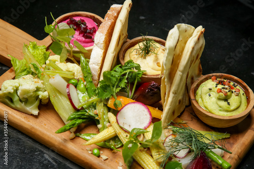 Exquisite dishes. Beautifly decorated healthy organic food served with avocado, beetrooth and classic chickpea hummus. Modern creative restaurant meal.  photo