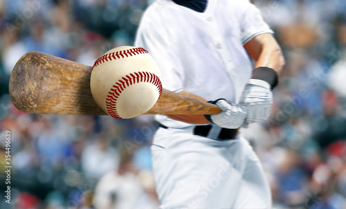 Baseball player hitting ball with bat in close up photo