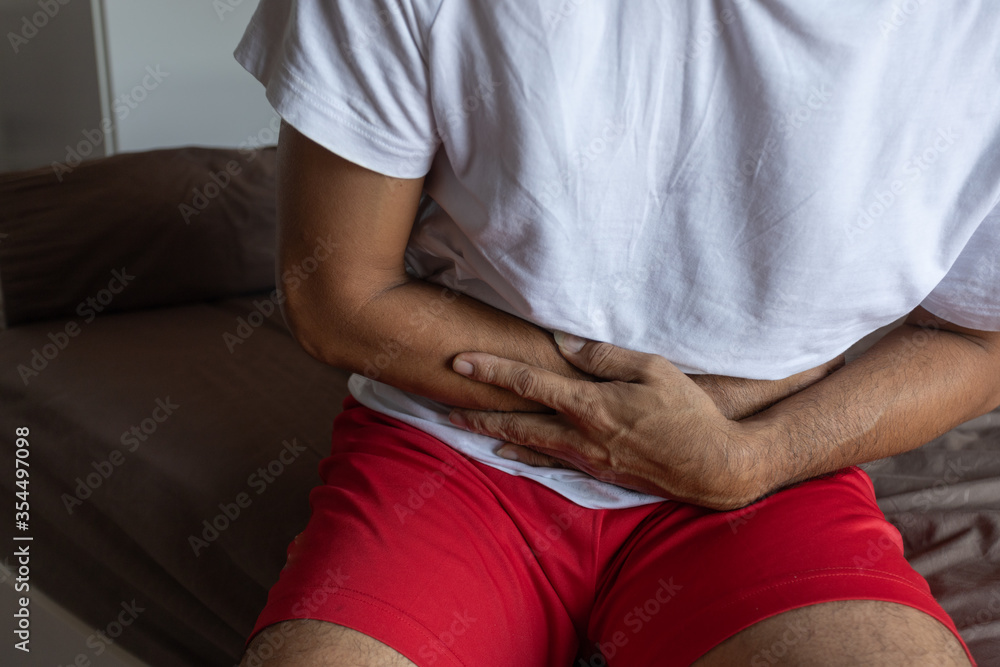 Young Man Suffering From Stomach Ache On the bed