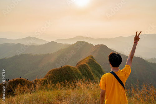 traveler man hiking enjoying in the mountains with backpack at Khao Chang Puak mountain Thailand photo