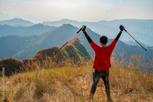 traveler man hiking enjoying in the mountains with backpack at Khao Chang Puak mountain Thailand