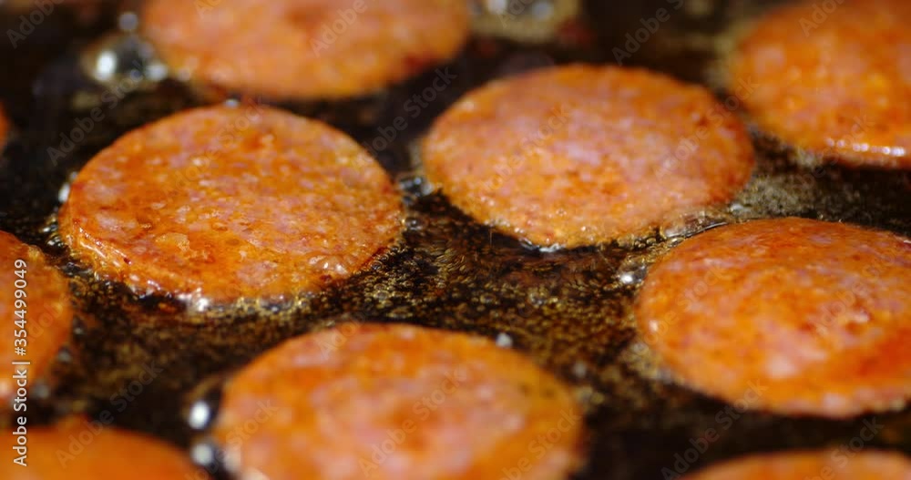 Pieces of sausage fried in oil with air bubbles and hot steam. Pieces of sausage fried in oil with air bubbles and hot steam.