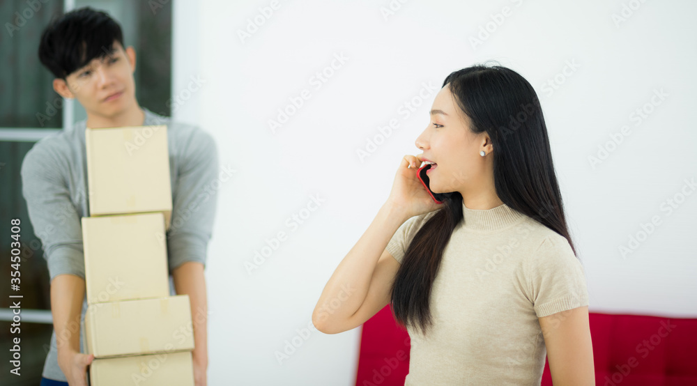 Asian woman customer from online shopping calling to order and delivery package in living room Asian woman customer from online shopping calling to order and delivery package in living room