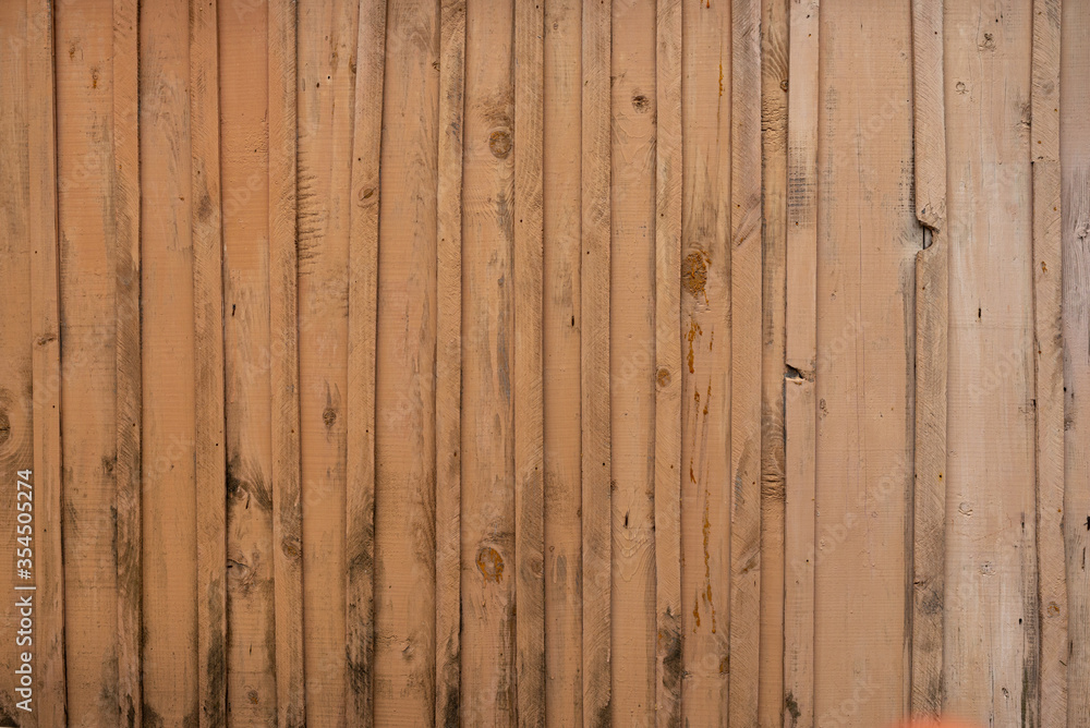 Texture of a yellow fence made of wooden boards