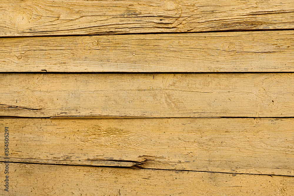 Texture of a yellow fence made of wooden boards