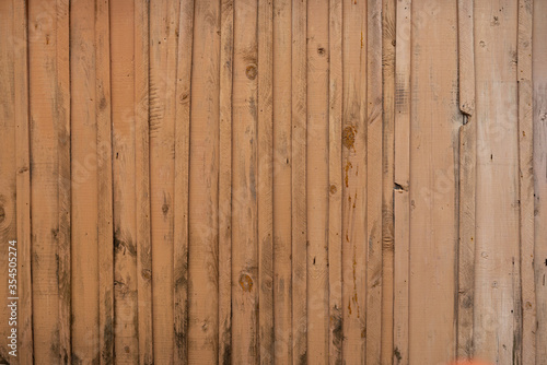 Texture of a yellow fence made of wooden boards