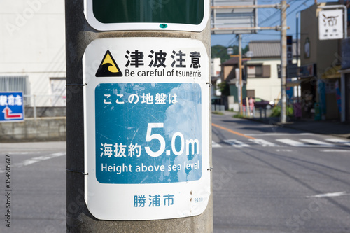katsuura, chiba, japan, 09/01/2019 , Be careful of tsunami sign, attached in every pole of the city telling also how high on the sea level it is.