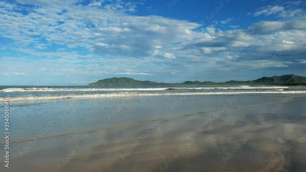 beautiful empty beach in costa rica with the mountains in the background. Waves splashing on shore. beautiful empty beach in costa rica with the mountains in the background. Waves splashing on shore.