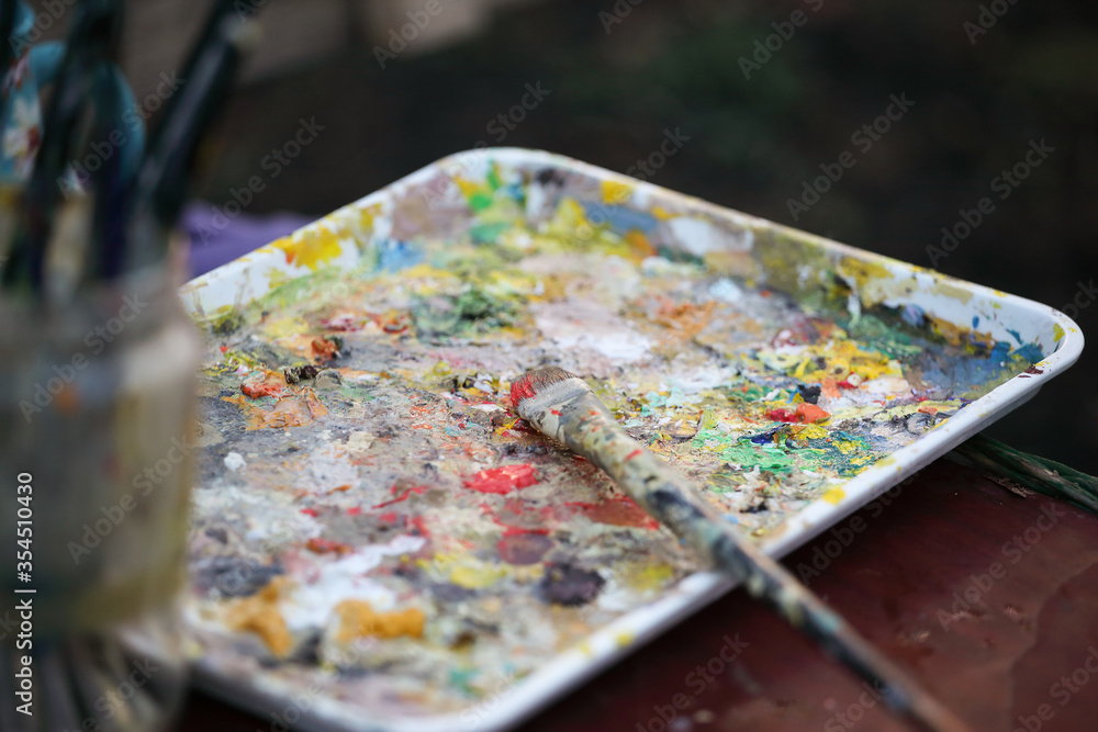 palette with paints and a paintbrush palette with paints and a paintbrush