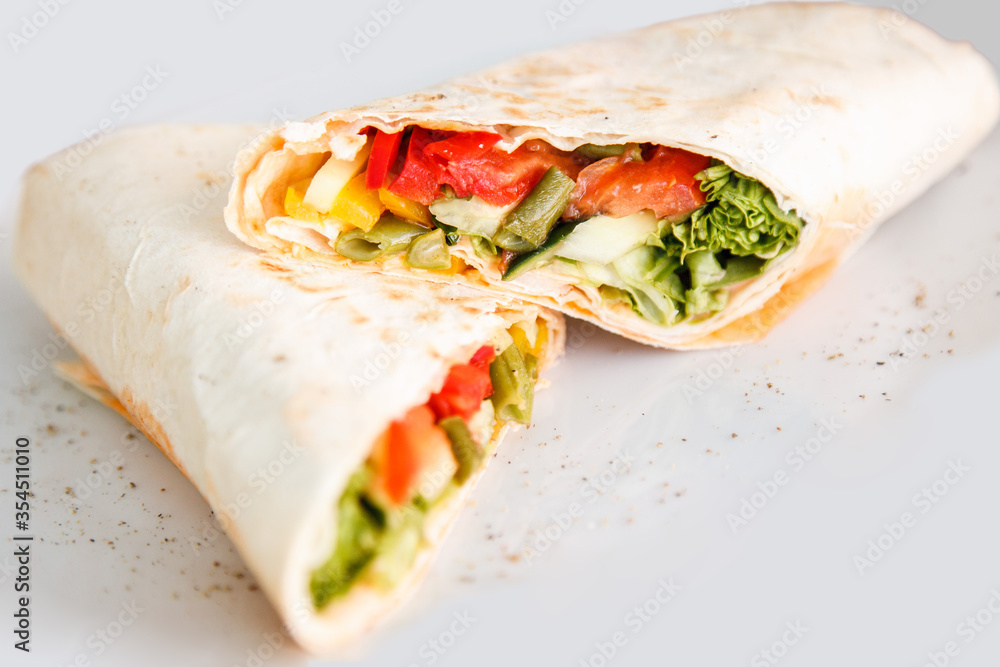 Obraz premium Shawarma sandwich - fresh roll of thin lavash or pita bread filled with grilled meat, mushrooms, cabbage, carrots