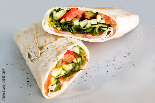 Shawarma sandwich - fresh roll of thin lavash or pita bread filled with grilled meat, mushrooms, cabbage, carrots