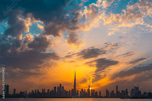 Beautifyul sunset over city in Dubai on cloudy day showing world's tallest building Burj Khalifa