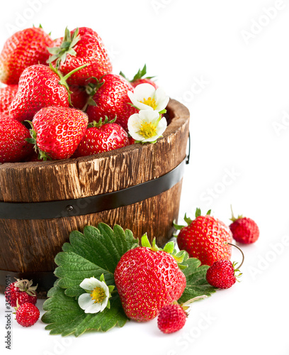 Fresh strawberry in wooden bucket with green leaf and flower. Isolated on white background.