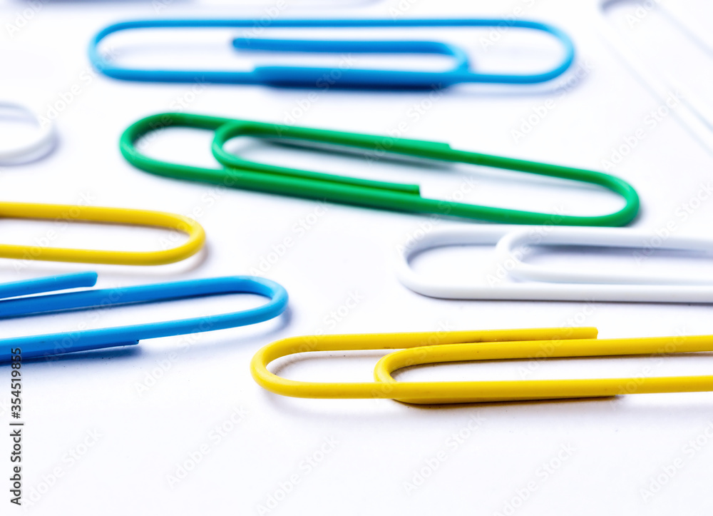 Colored paper clips close-up on a white background Colored paper clips close-up on a white background