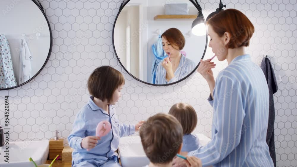 Mother with small children in pajamas in bathroom at home, brushing teeth. Mother with small children in pajamas in bathroom at home, brushing teeth.
