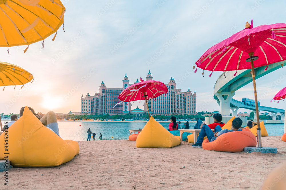 Beach view in Dubai with umbrellas and chairs and bean bags overlooking  atlantis hotel on Palm islands in Dubai Stock-Foto | Adobe Stock