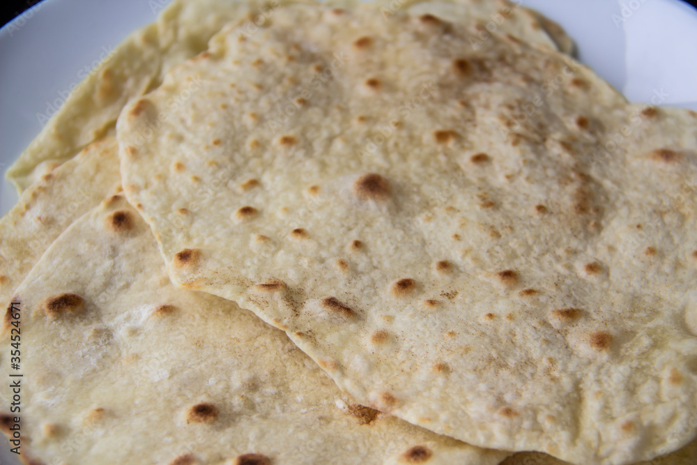 Delicious pita bread made at home in a pan. Thin pita bread on a white plate