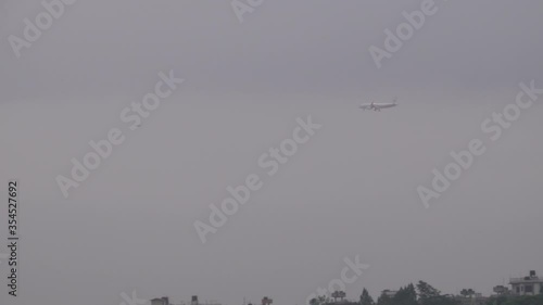 An airplane flying through the clouds and mist while descending for a landing at the Kathmandu airport in Nepal. photo