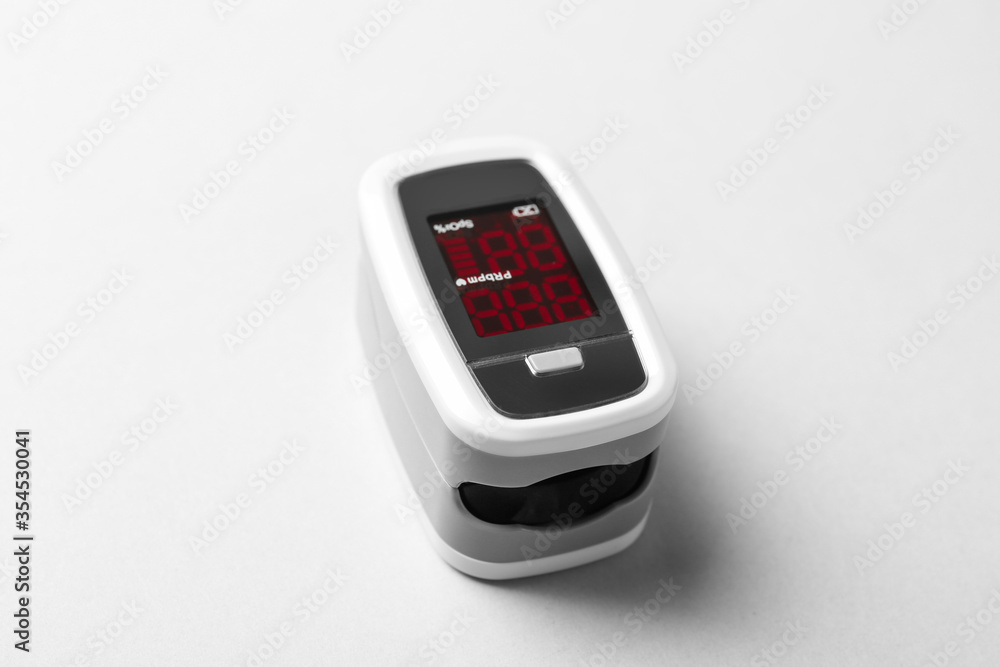 Modern fingertip pulse oximeter on white background, closeup Modern fingertip pulse oximeter on white background, closeup