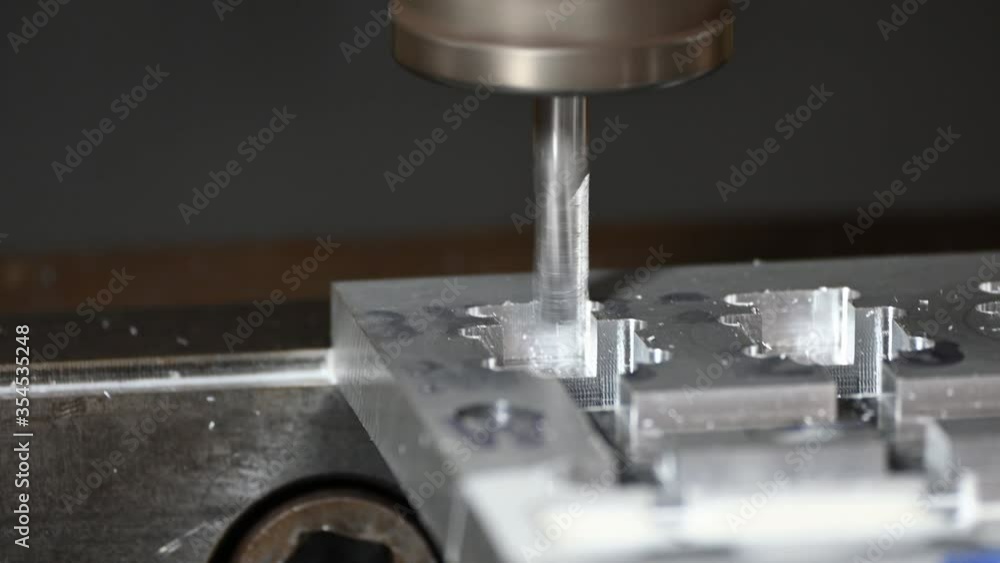 The CNC milling machine cutting the aluminium parts by solid endmill tool. The hi-precision manufacturing concept by machining center. The CNC milling machine cutting the aluminium parts by solid endmill tool. The hi-precision manufacturing concept by machining center.