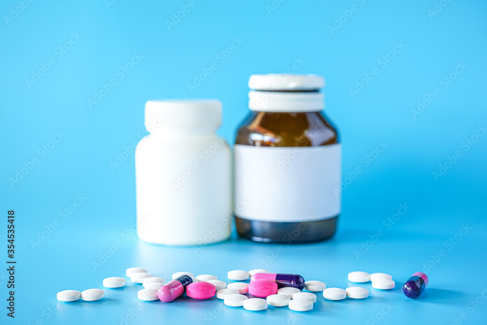 tablets pill and capsules on blue background with bottle tablets pill and capsules on blue background with bottle