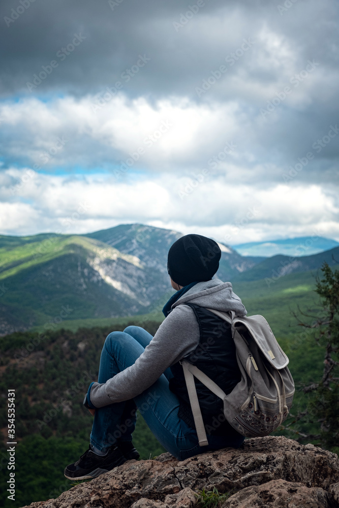 Young traveling woman on the top of the mountain cliff Young traveling woman on the top of the mountain cliff