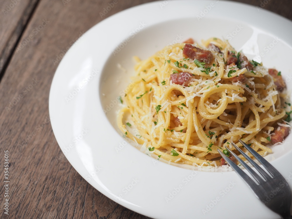 Carbonara spaghetti in white dish on wooden background