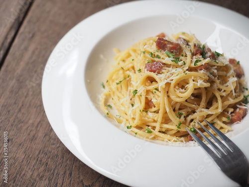 Carbonara spaghetti in white dish on wooden background