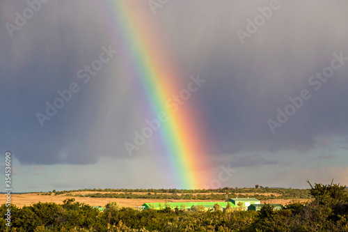 Colorful and bright rainbow over the village in Patagonia region, Chile. Beautiful rainbow after the rain.