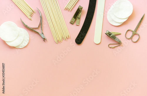 Flat lay of tools for manicure and pedicure on a pink background. Space for text