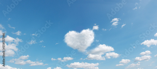 Fototapeta Naklejka Na Ścianę i Meble -  panoramic sky with flying clouds with heart shape. love romantic theme photo in high resolution