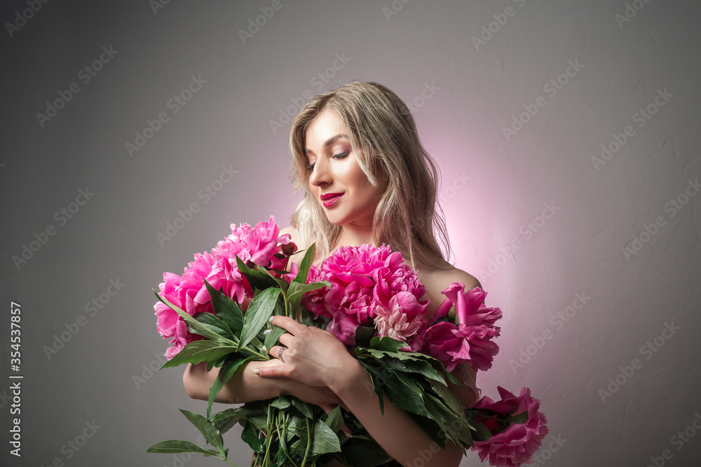 Portrait of beautiful young woman with pink peonies. Spring summer skincare beauty, spa and body care concept