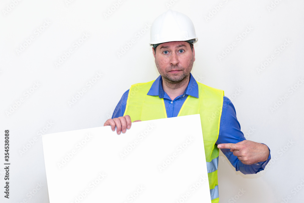 Close-up Engineer man wearing a helmet and reflector vest, standing and poke to a billboard. White background. Close-up Engineer man wearing a helmet and reflector vest, standing and poke to a billboard. White background.