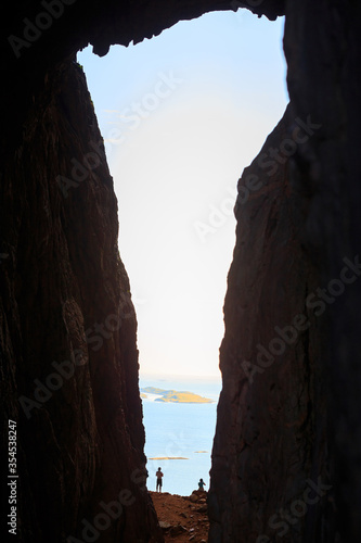 Children silhouette through a hole in Torghatten mountain in Norway